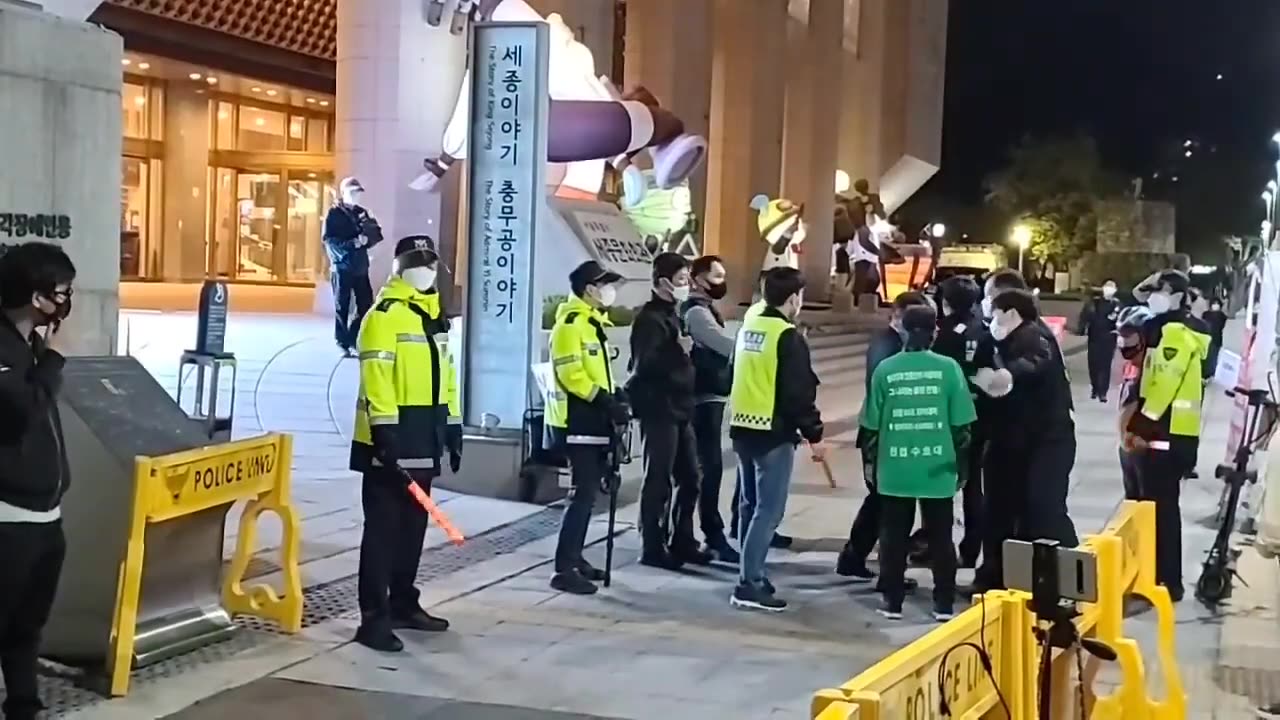 20210416_V3_S04(XQ1vCDyfH3o)폴리스라인이 설치된 문화제 앞을 지나는 현수막을 든 일인시위와 정보관