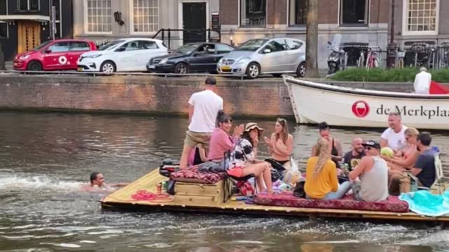 Guy Pushes Raft of People Down Canal