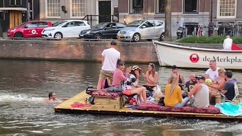 Guy Pushes Raft of People Down Canal