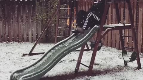 Collab copyright protection - mom goes down green slide in snow