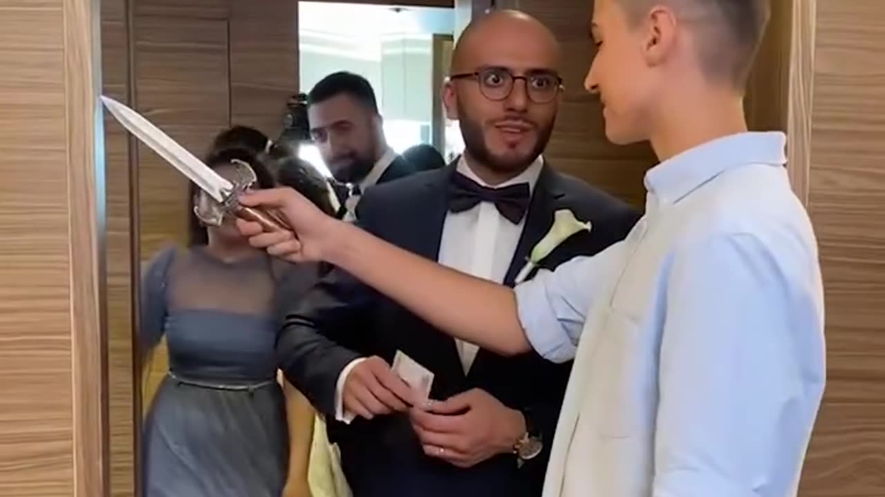 Lad blocks doorway so newlyweds can't leave