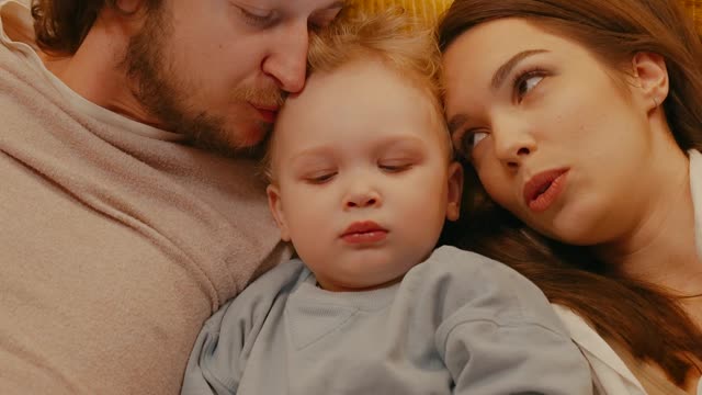 parents reading a book for their daughter