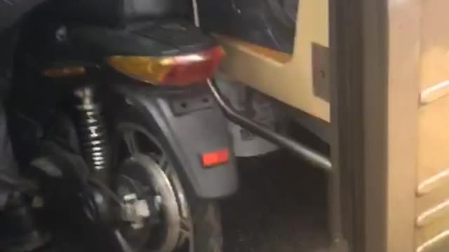 Man takes his motorcycle bike into a crowded subway train