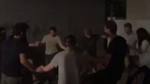 Friends dance in circle outside at night