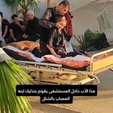 A Palestinian father tenderly massages his son, who has...