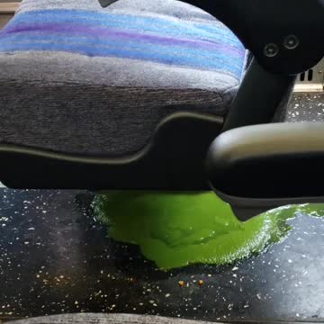 Green liquid on subway train under blue chair