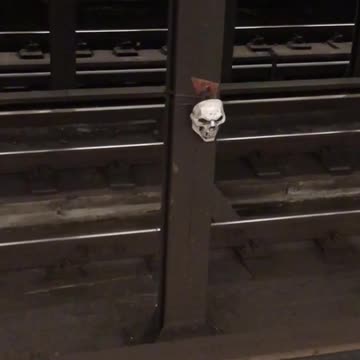 Skull tied to pillar in subway tracks