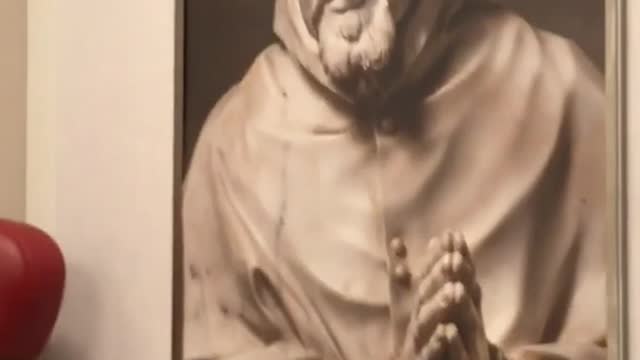 Man compares picture on phone to poster on wall