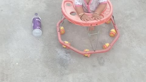 Baby playing with walker and water bottle