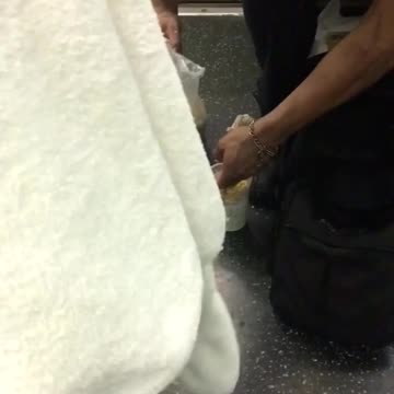 Man prepares meal on subway train floor