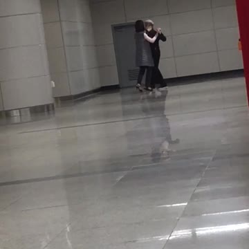 A couple ballroom dances on subway platform