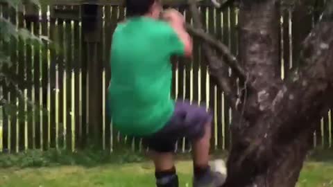 Boy in green breaks tree branch