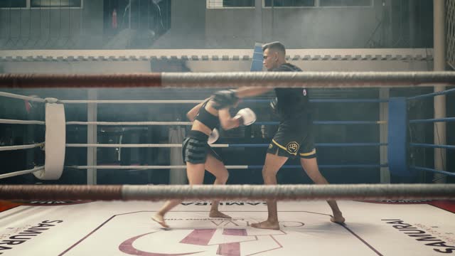 Female kickboxer training with her coach