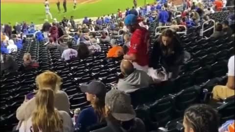 This guy is playing on his phone while watching the game