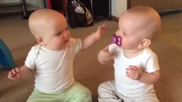 Twin baby girls fight over pacifier