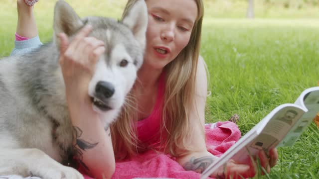 Woman Lying on a Blanket with a Dog