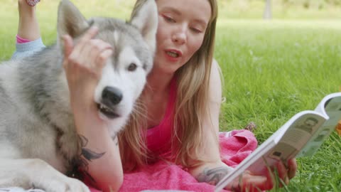 Woman Lying on a Blanket with a Dog