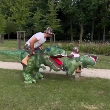 Dinosaur funny costume kid and father playing in park. amusement entertaining activity