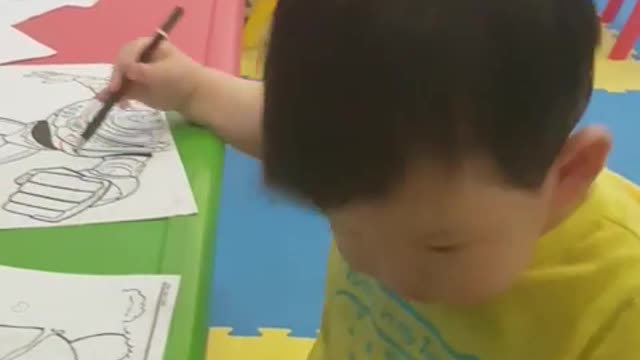 This is a video of a baby who is coloring like a painter.