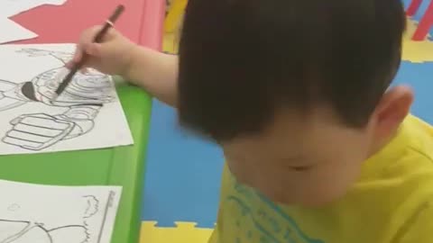 This is a video of a baby who is coloring like a painter.