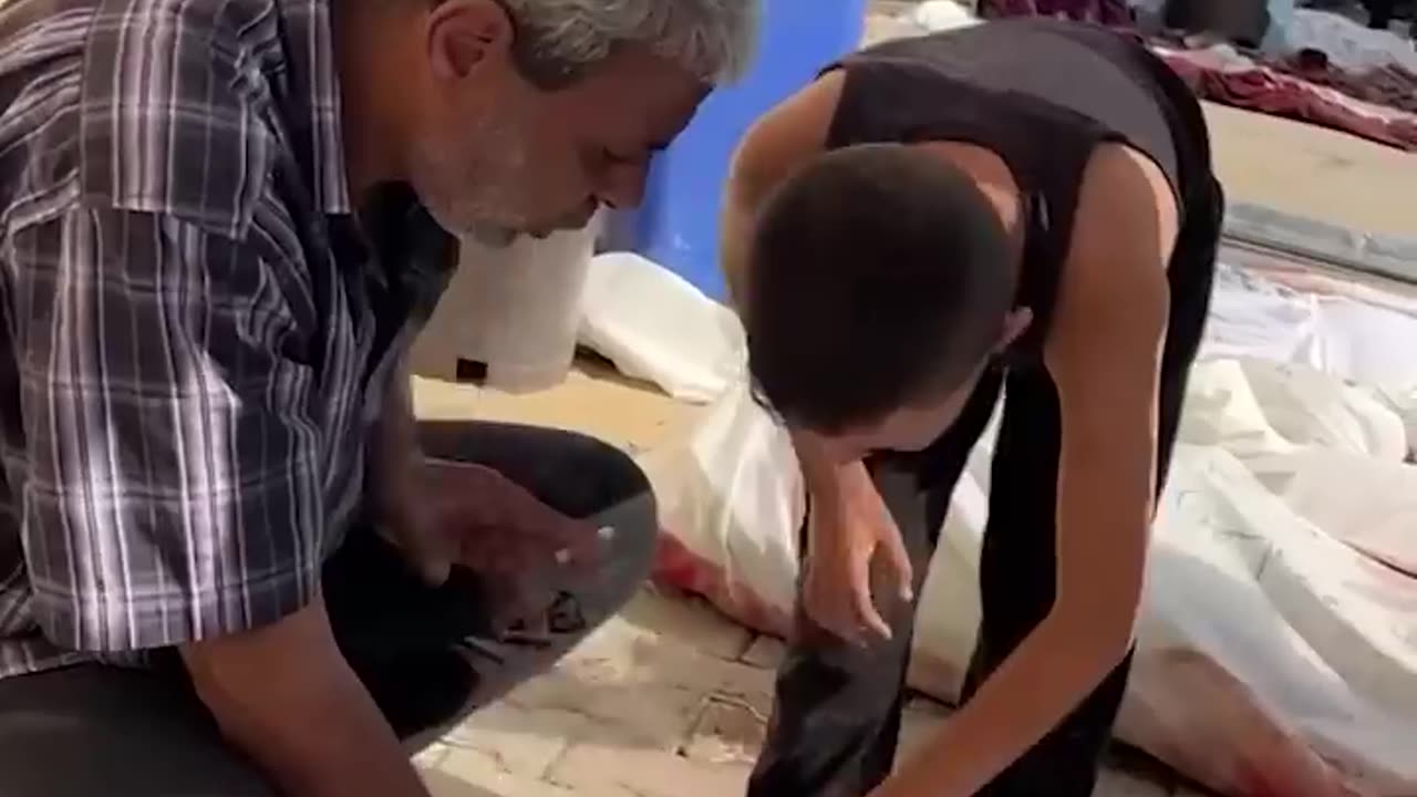 Palestinian boy looks for his family members' bodies among the dead