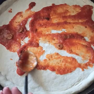Homemade Pizza Adding Sauce