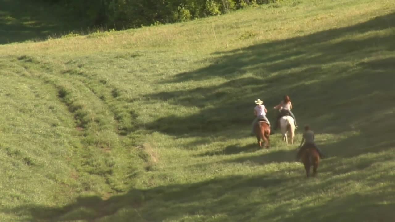 Three Young Women On Horses Gallop Across Green MeadowâÃÃ¬with Dust