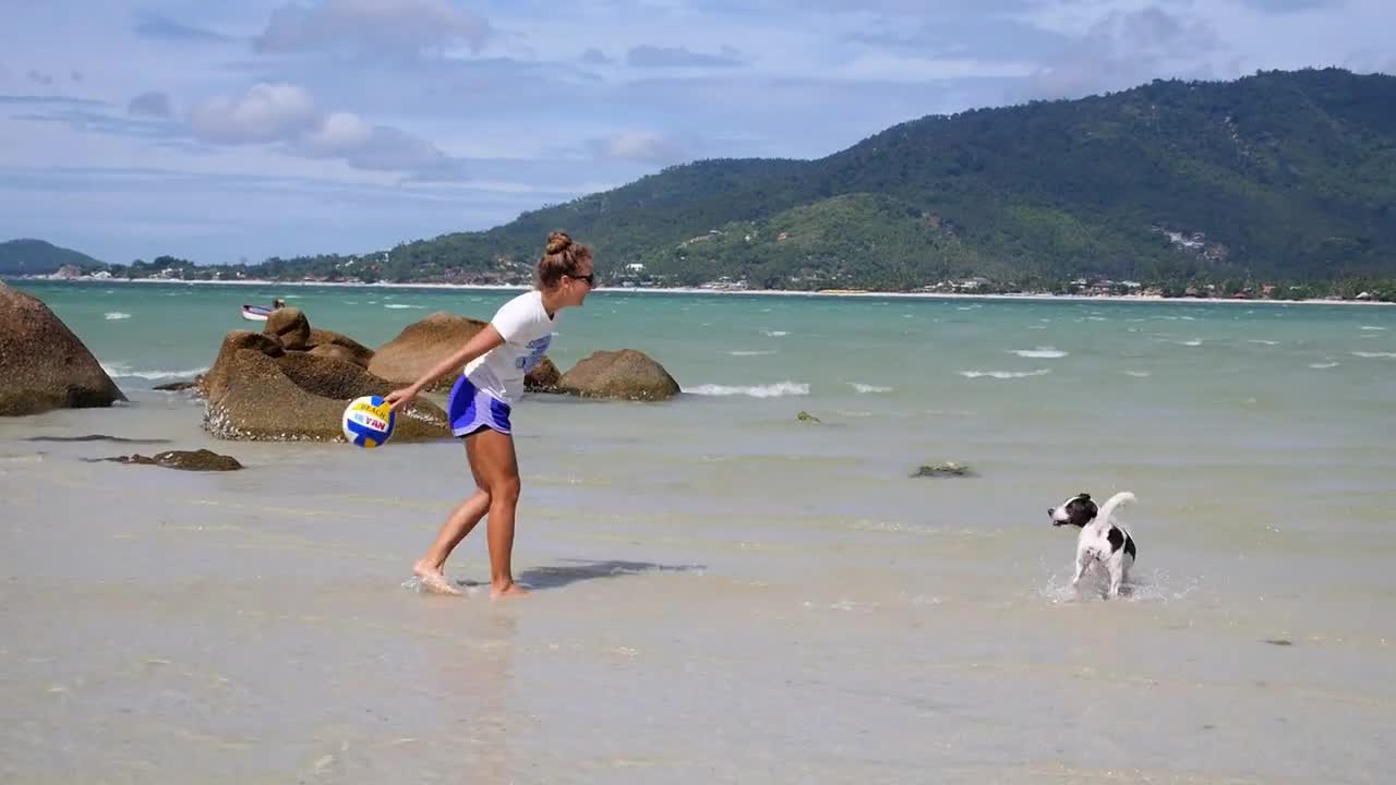 Young Woman Playing with Dog on Beach