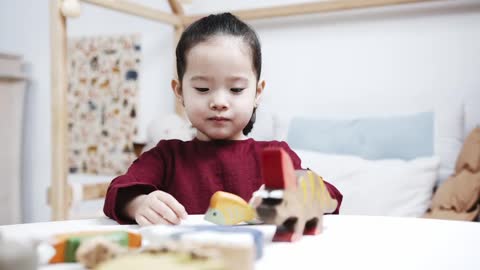 A Young Girl Playing With Wooden Sea Animal Toys