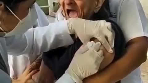 old woman being vaccinated against covid