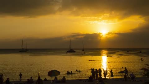 Time-lapse of a sunset in a crowded beach
