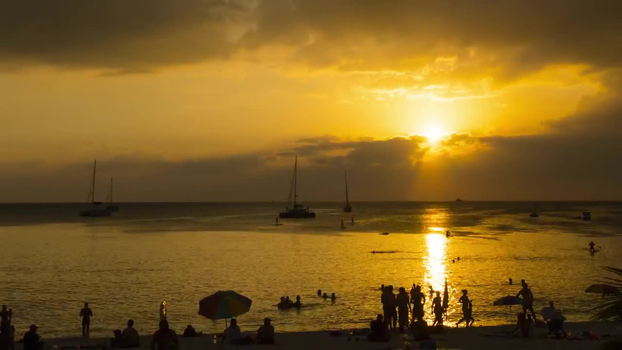 Time-lapse of a sunset in a crowded beach