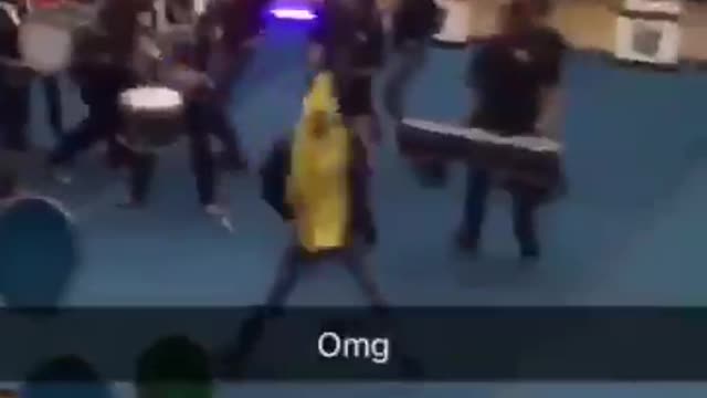 Guy dressed in banana costume runs through pep rally