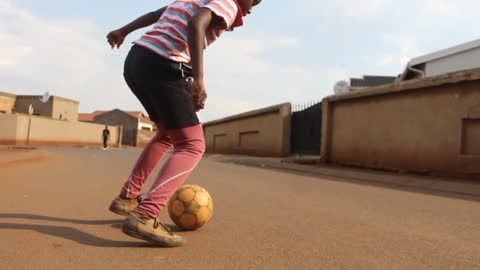 South African ghetto boy playing soccer.