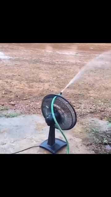Watering the garden with a hose and a fan