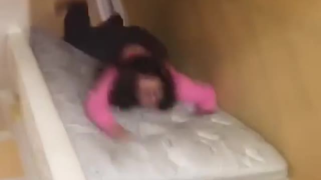 Girl pink shirt glasses mattress stair slide fail face plant