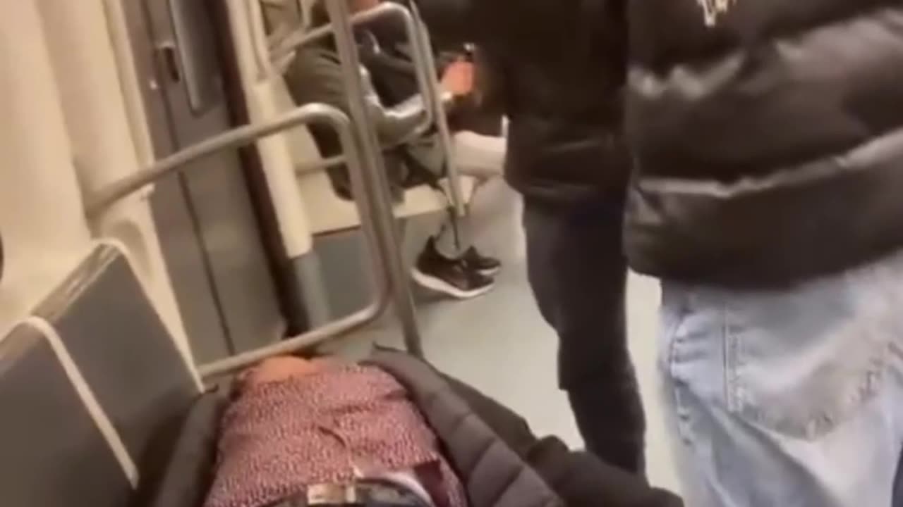 Un chaval intenta despertar a un hombre en el metro