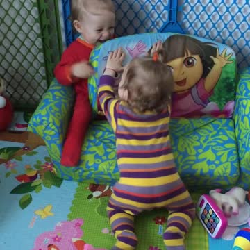 Twin baby girls play together