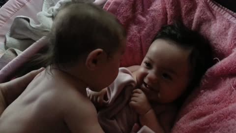 A baby laughing with his little sister