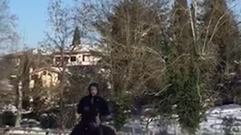 Guy runs with horse in snow and horse falls down