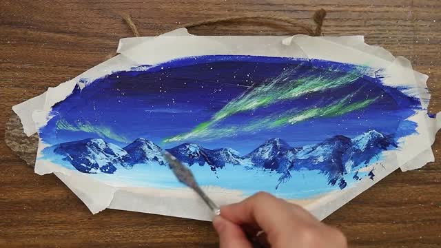 The aurora borealis in the snowy mountain hut is very beautiful.