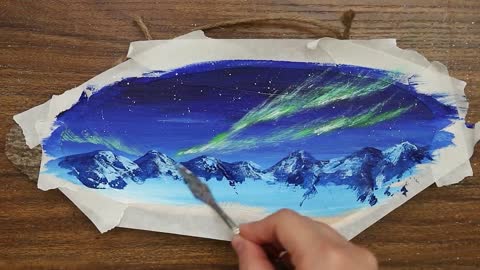 The aurora borealis in the snowy mountain hut is very beautiful.