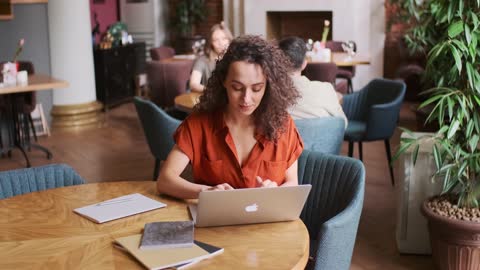 Woman Using Laptop In A Restaurant