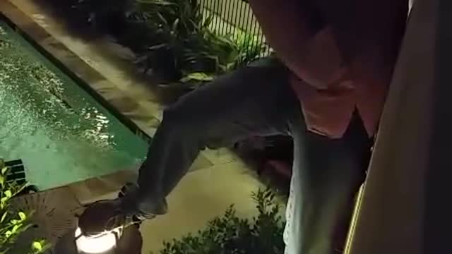 Guy breaks light as he falls from railing in courtyard