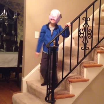 Kid Walks Around House Singing With A Diaper On His Head