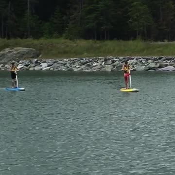 Two people on paddle boards in lake