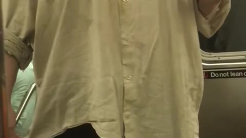 Person long white shirt singing hot in here subway holding cup