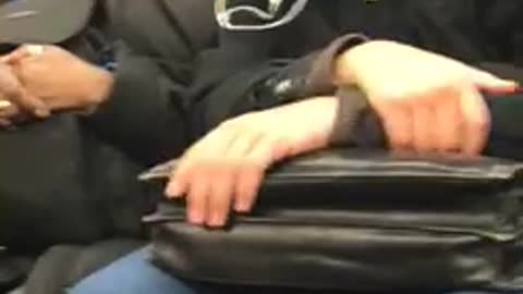 Man and woman share ear phones on subway train