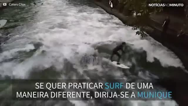 Jovem pratica surf em um rio de Munique