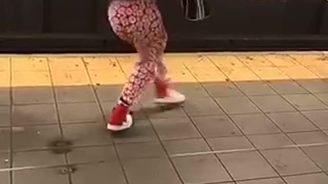 731am girl dancing on subway platform red pants